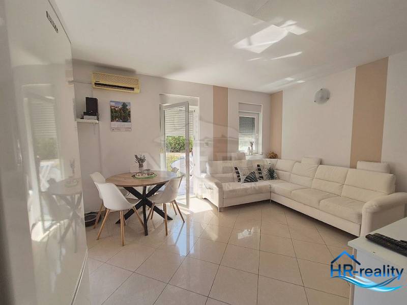 Living room in a two-room apartment with a white couch and a dining table.