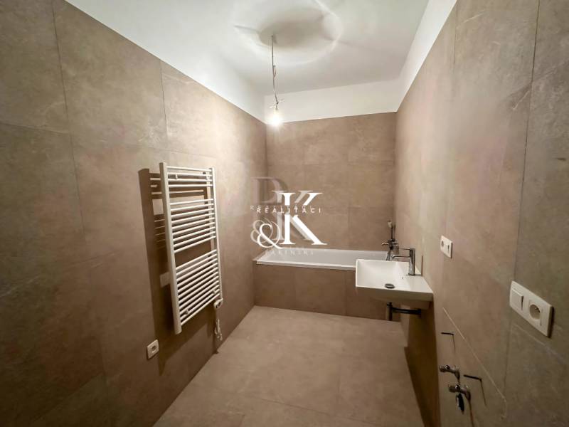Bathroom in a 3-room apartment with a sink, bathtub, and tubular radiator.