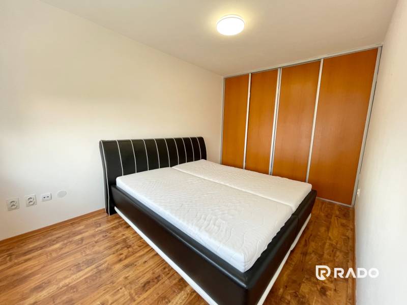 Bedroom with a large bed and built-in wardrobe in a 2-room apartment.
