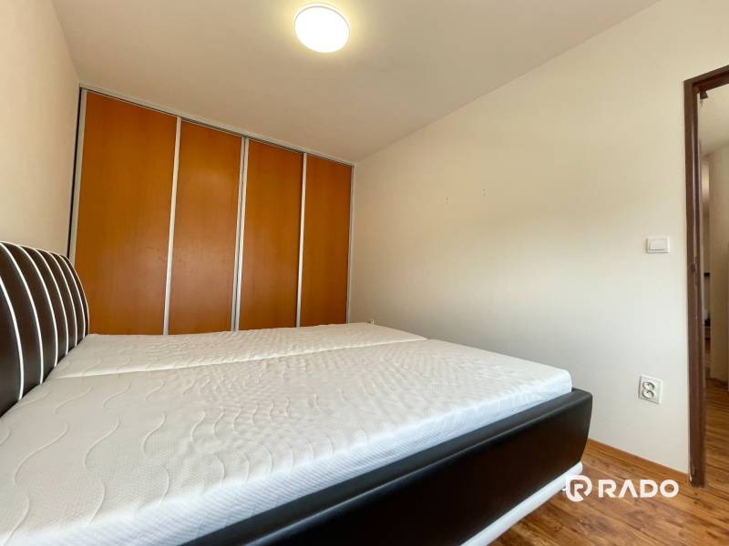 Bedroom in a 2-room apartment, with a large bed and a built-in wardrobe.