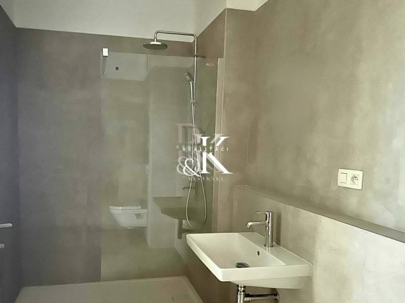 A stylish bathroom with an elegant shower and sink in a 2-room apartment.