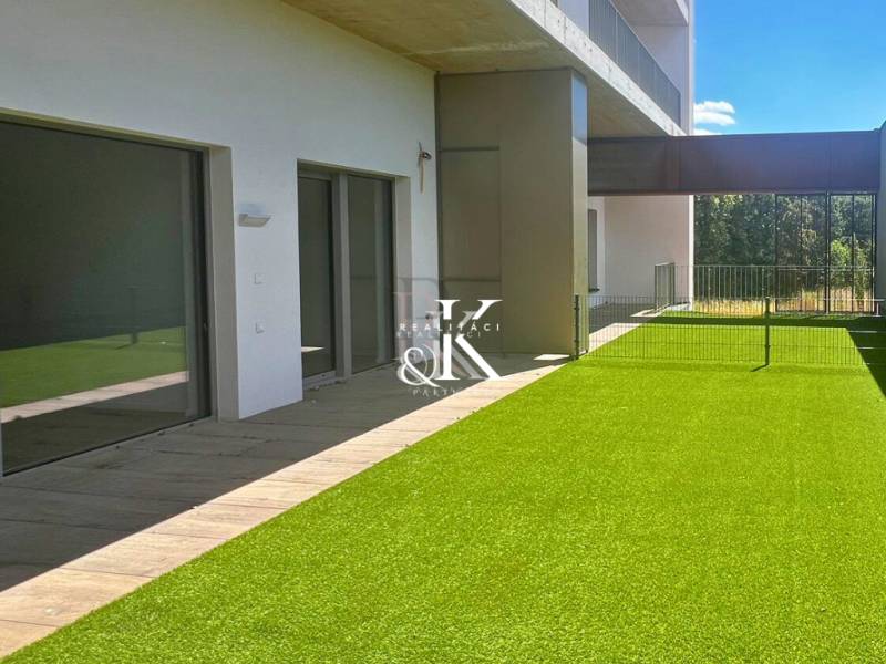 A terrace with artificial grass and sliding doors of the Recreational Apartment in Banka.