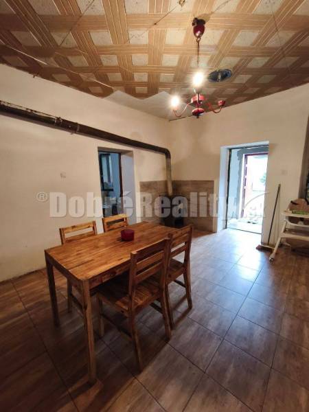 Dining room in a family house with a table, chairs, and a suspended ceiling.
