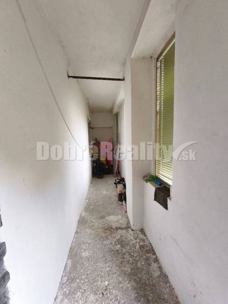 A narrow hallway with a shoe rack in a family house.
