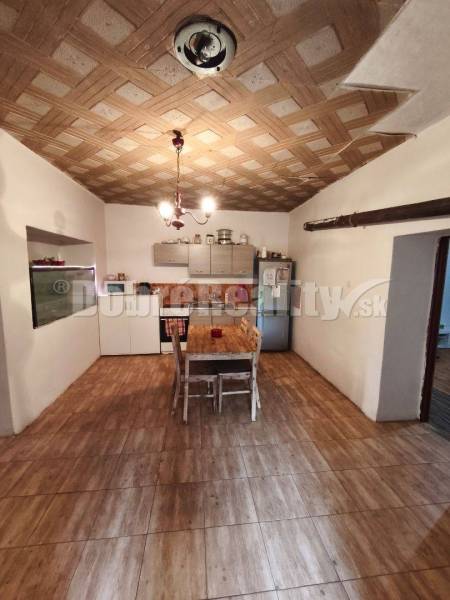 Interior of a family house with a kitchen unit, dining table, and wooden floor.