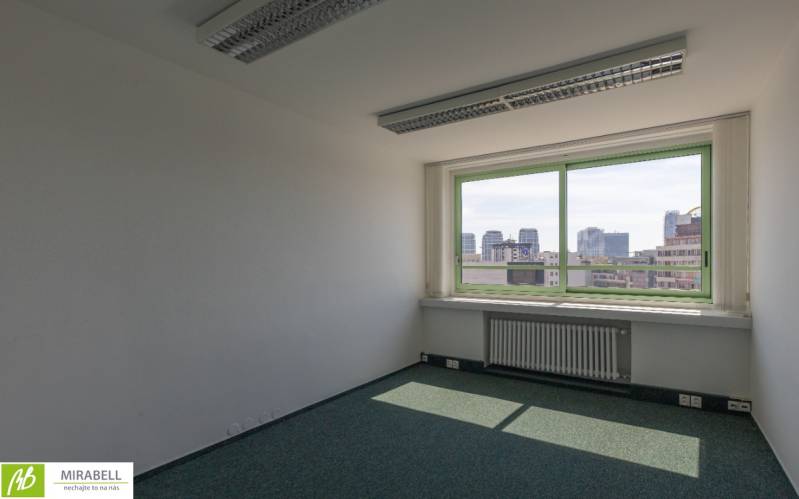 Empty office with a view of the city skyline through a large window.
