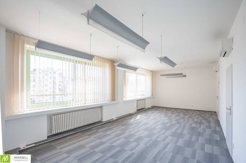 Spacious offices with pendant lights and vertical blinds.