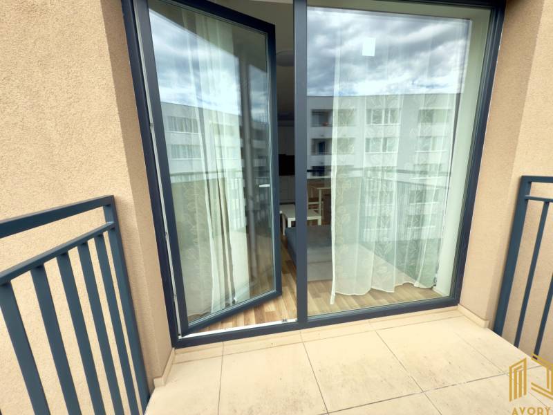 A balcony with sliding doors to a 2-room apartment, view of the street.