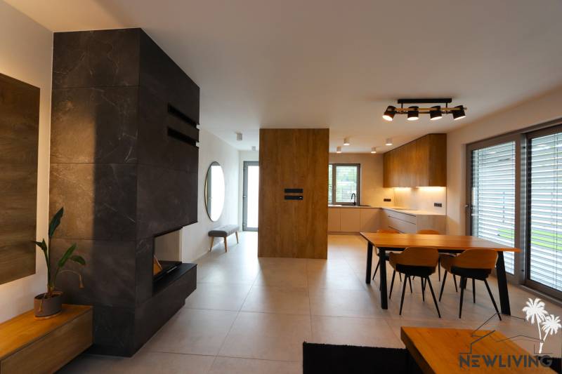 Interior of a family house with a kitchen, dining table, and modern fireplace.
