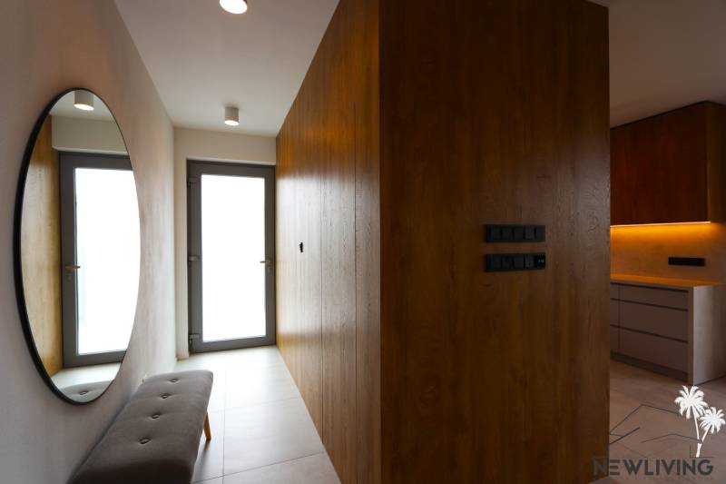 A hallway in a family house with a large mirror and wooden paneling.