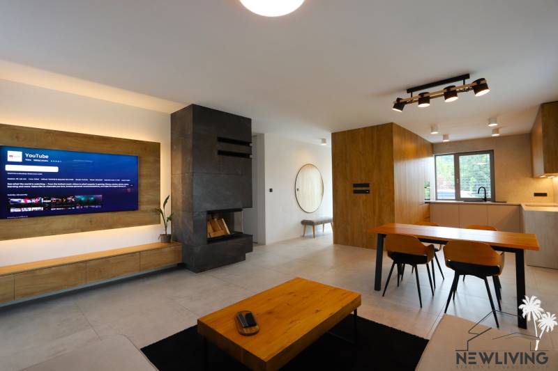 Living room in a family house with a fireplace, television, and dining area.