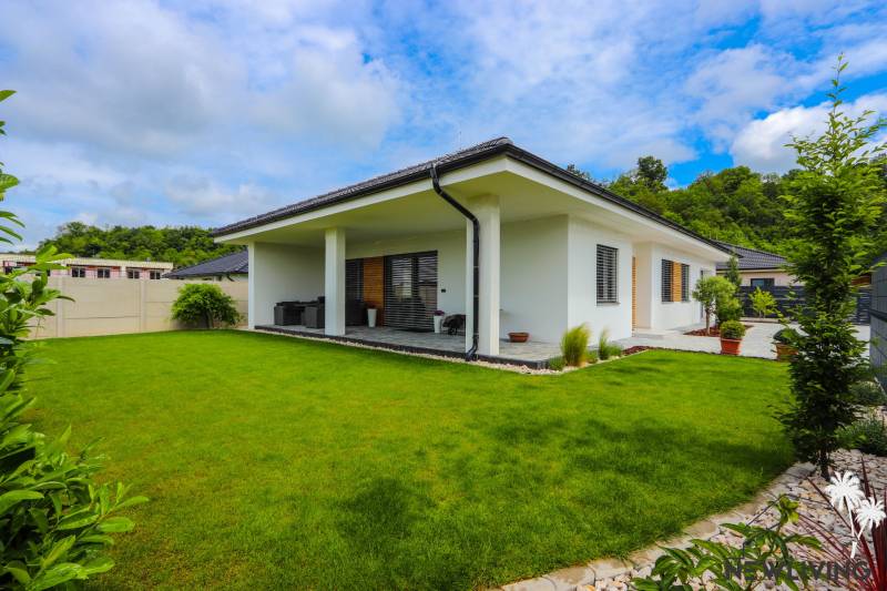 A family house in Piešťany with a glass terrace and a green lawn.