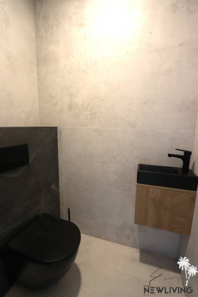Black and white bathroom with a wall-mounted vanity unit in a family house.