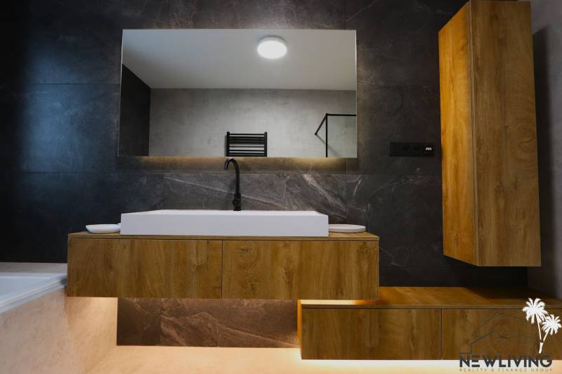 A bathroom with a sink and a wooden cabinet in a family house.
