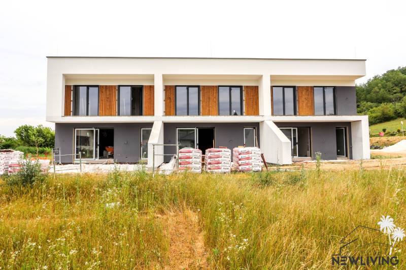 A family house in Piešťany with large windows, two floors, and an unfinished garden.