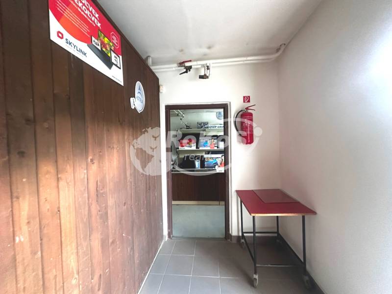 A corridor in commercial premises with wooden paneling and a fire extinguisher.