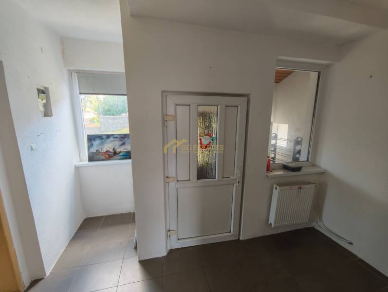 The interior of a family house with white walls, plastic doors, and a radiator under the window.