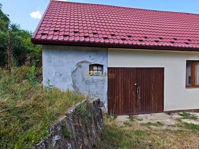 A family house on Dlhá Street in Vranov nad Topľou with a red roof and a wooden garage.
