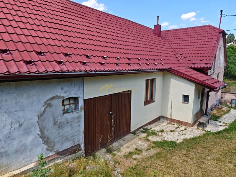 A family house on Dlhá Street in Vranov nad Topľou with a red roof and a garage door.