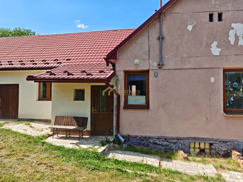 A family house on Dlha Street in Vranov nad Topľou with a red roof and a bench.