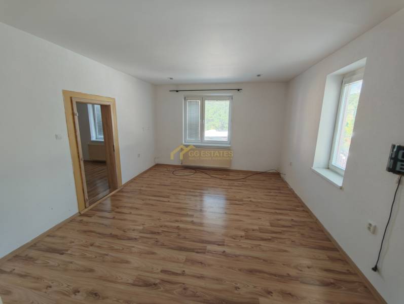 A room in a family house with a wooden floor and white walls.