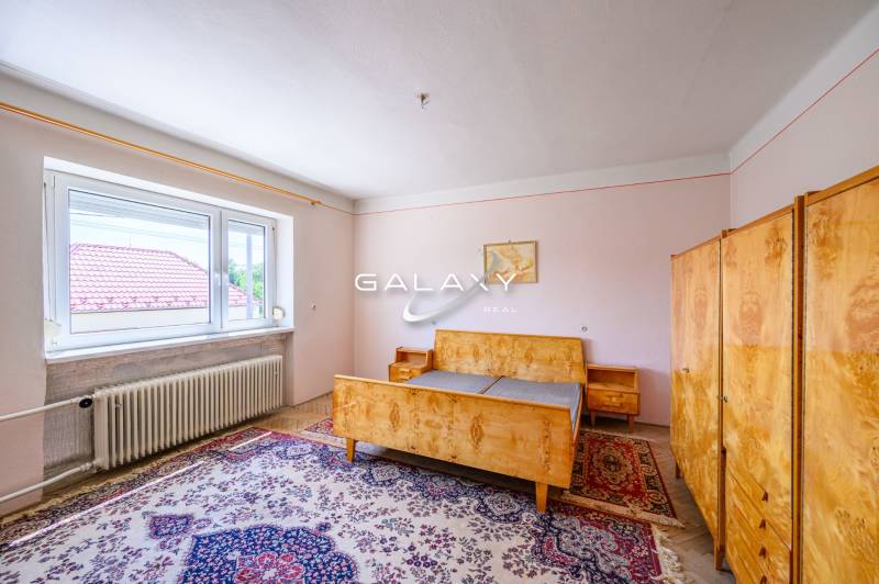 A bedroom in a family house with antique furniture and a carpet.