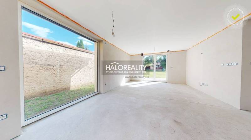 A view from the interior of a family house with large windows and a view of the garden.