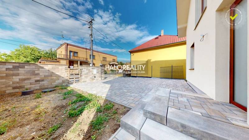 A family house in Rimavská Sobota with a paved area, garden, and brick fence.