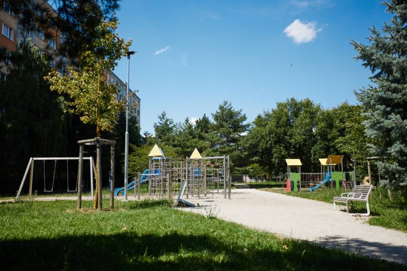 A playground surrounded by greenery and apartment buildings, Košice - Juh district.
