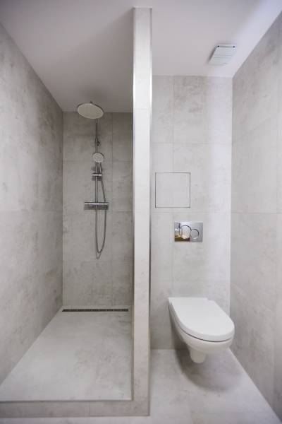 Bathroom with a shower and toilet, minimalist style in a 2-room apartment.