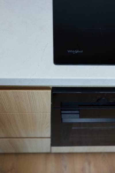 A kitchen unit in a 2-room apartment with a built-in cooktop and oven.