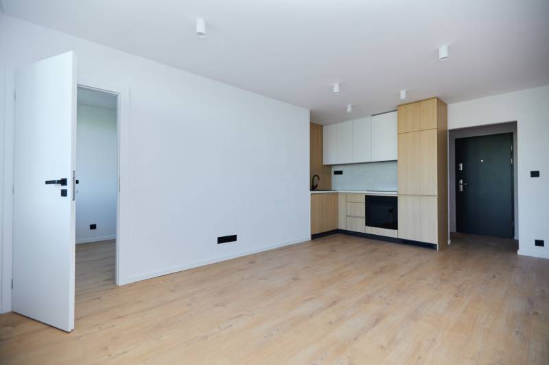 Kitchen in a 2-room apartment with wooden flooring and built-in appliances.