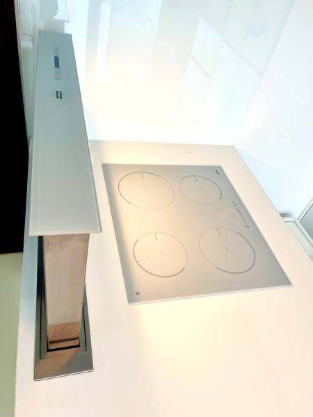 A kitchen countertop with a built-in cooktop and extractor in a 2-room apartment.