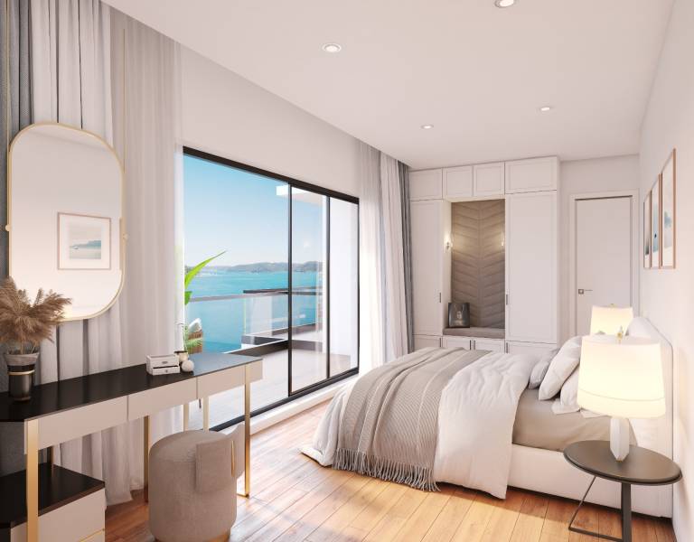 A sunlit bedroom in a villa with a view of the sea from a private balcony.