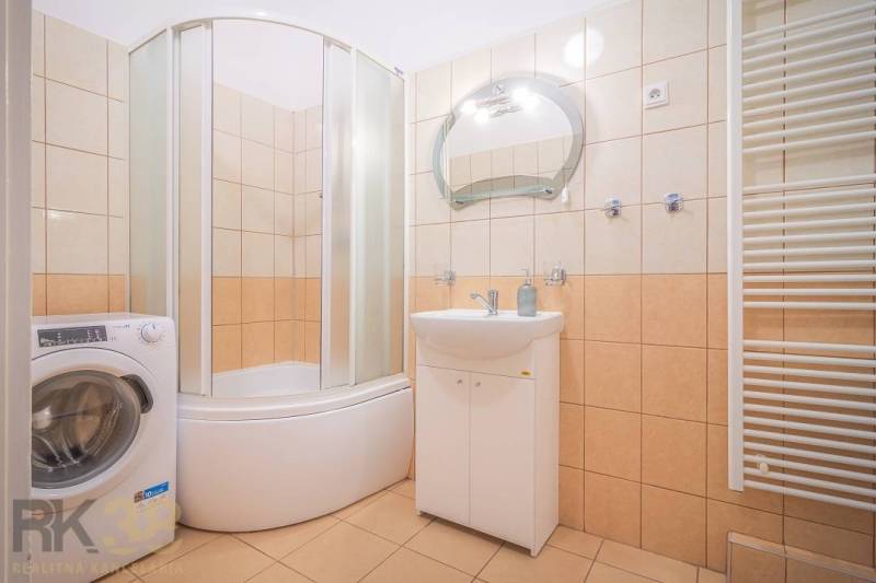 Bathroom in a 3-room apartment with a shower, washing machine, and sink.