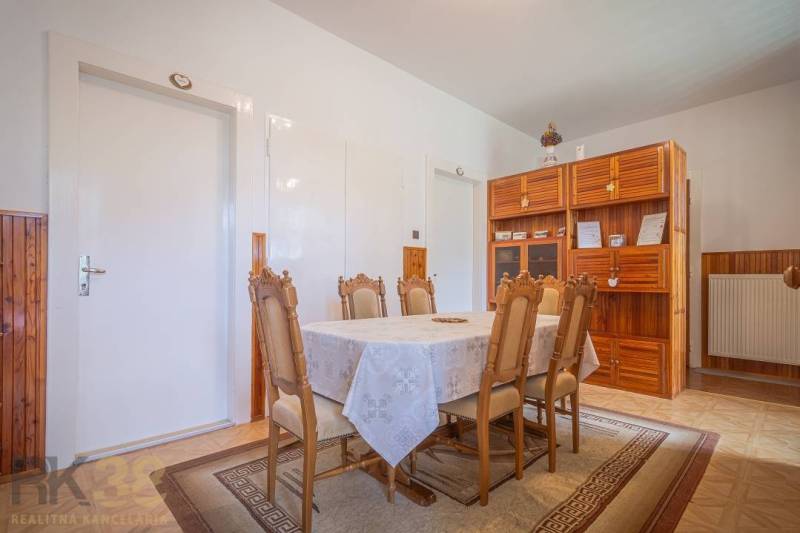 Dining room with table and chairs, wooden cabinet, radiator, 3-room apartment.