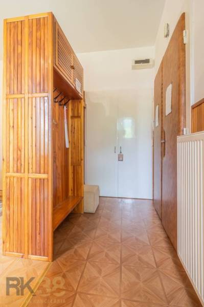 Hallway in a 3-room apartment with wooden cabinets and white doors.