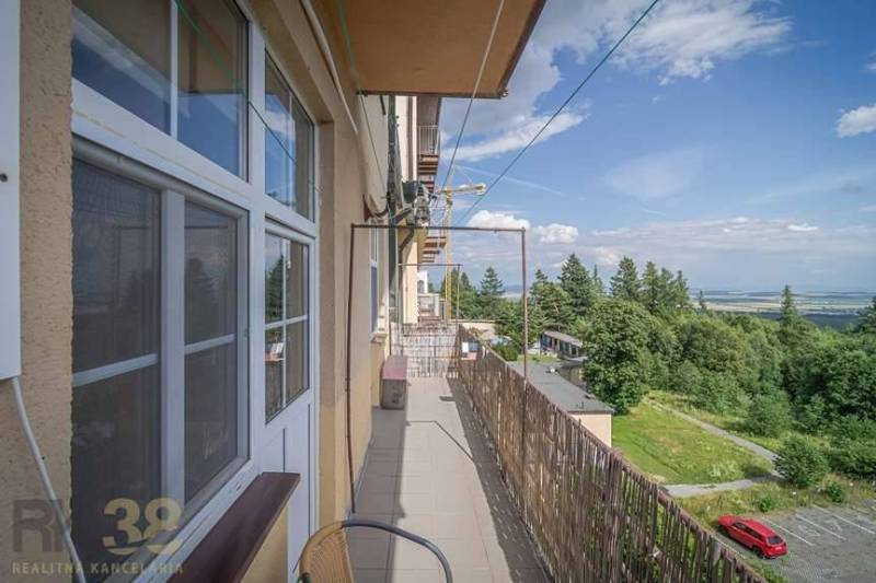 The balcony of a 3-room apartment in the High Tatras with a view of nature and a parking lot.