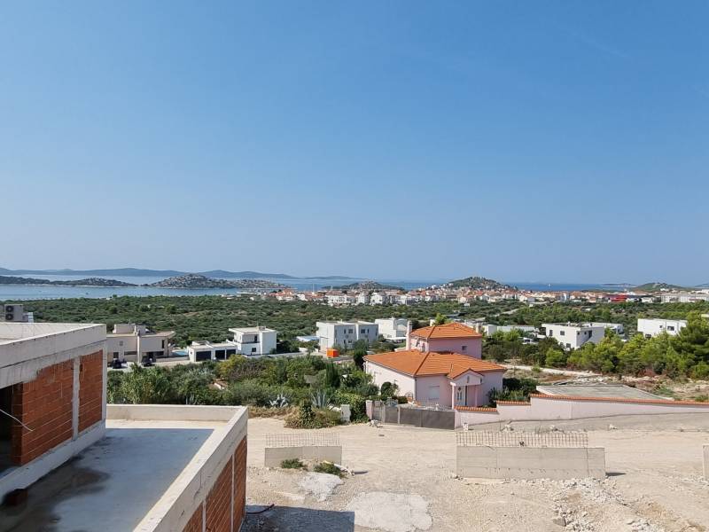 Sea view from the villa in Vodice with part of the construction and greenery.