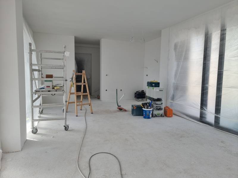 Interior renovation in a villa with a ladder, tools, and foil on the floor.