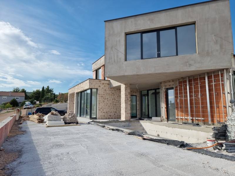 A villa in Vodice during construction works with exterior materials and a view of the surroundings.