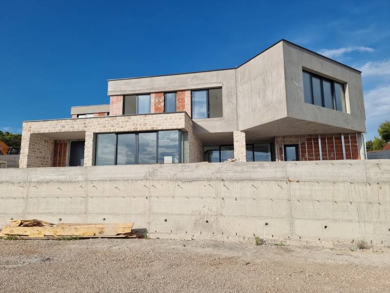 The exterior of the villa in Vodice with modern windows and raw concrete.