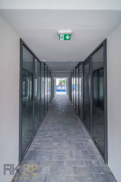 A glazed corridor with emergency lighting in commercial premises.