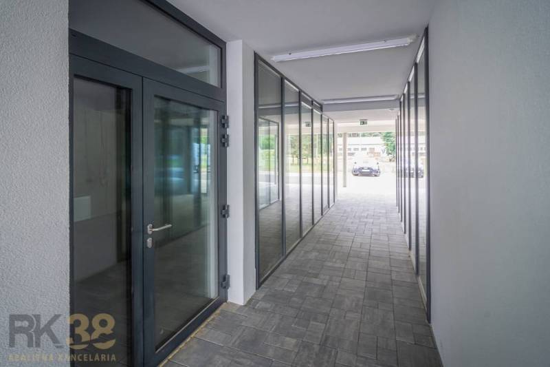 Hallway of commercial spaces with glass doors and a view of the exterior.