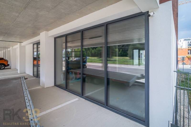 Glazed commercial spaces in Svit with parking and modern architecture.