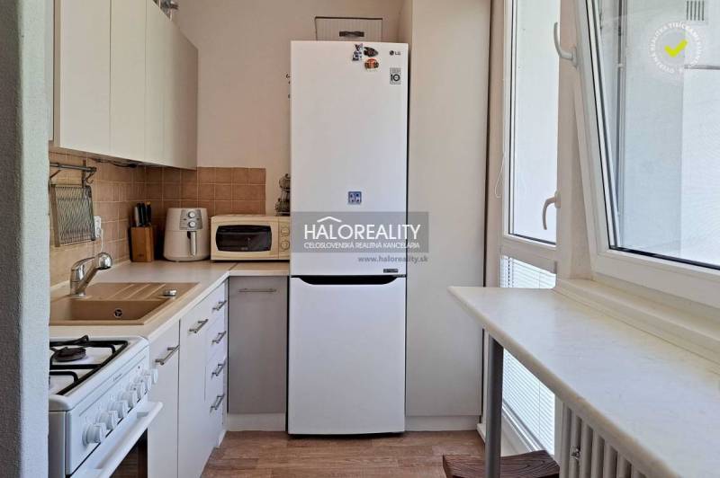 A kitchen in a 3-room apartment with a fridge, microwave, and stove.