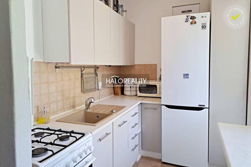 A kitchen in a 3-room apartment with a gas stove and a white refrigerator.