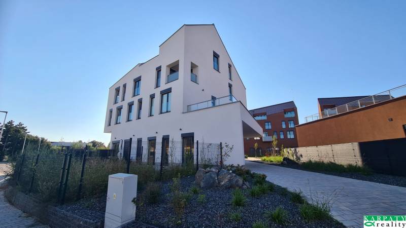 A new building on Perlová Street in Bratislava - Jarovce with modern windows and landscaped surroundings.