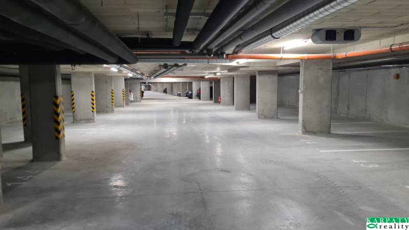Underground garage with parking spaces and concrete columns in a studio apartment.