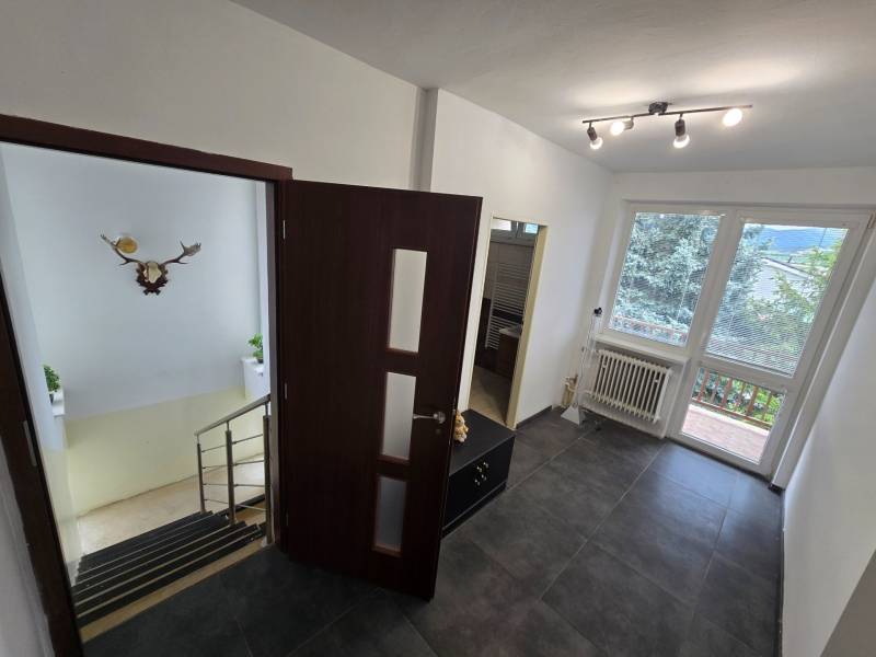 Interior of a family house with a hallway, staircase, and a spacious view of the garden.